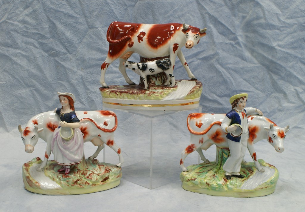 Appraisal: Staffordshire cow figurines girl with repaired arm cow with repaired