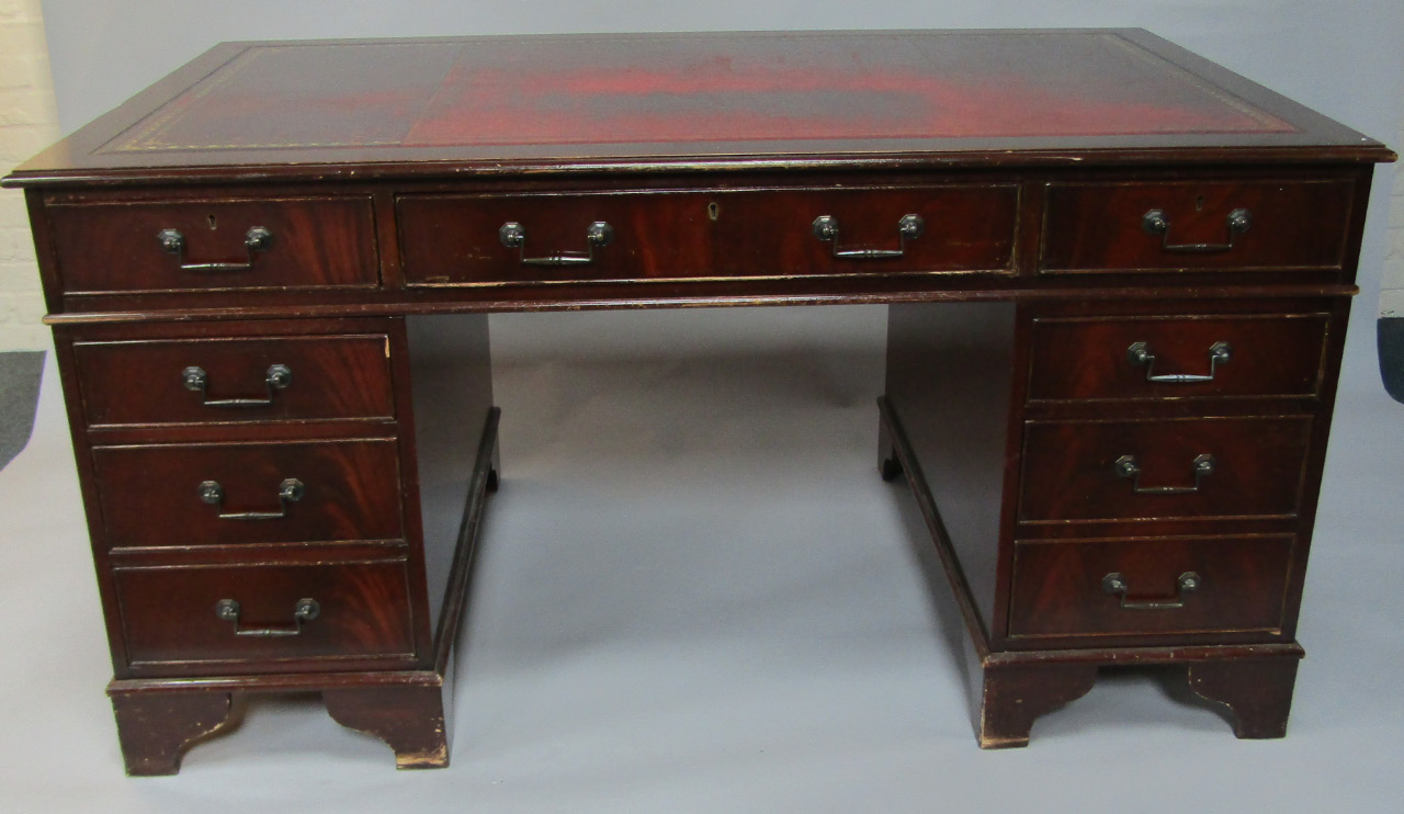 Appraisal: A mahogany twin pedestal desk with a gilt tooled red