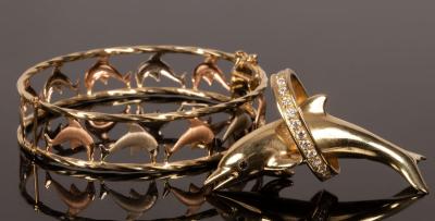 Appraisal: An Italian bi-colour k gold bangle with pierced textured dolphin