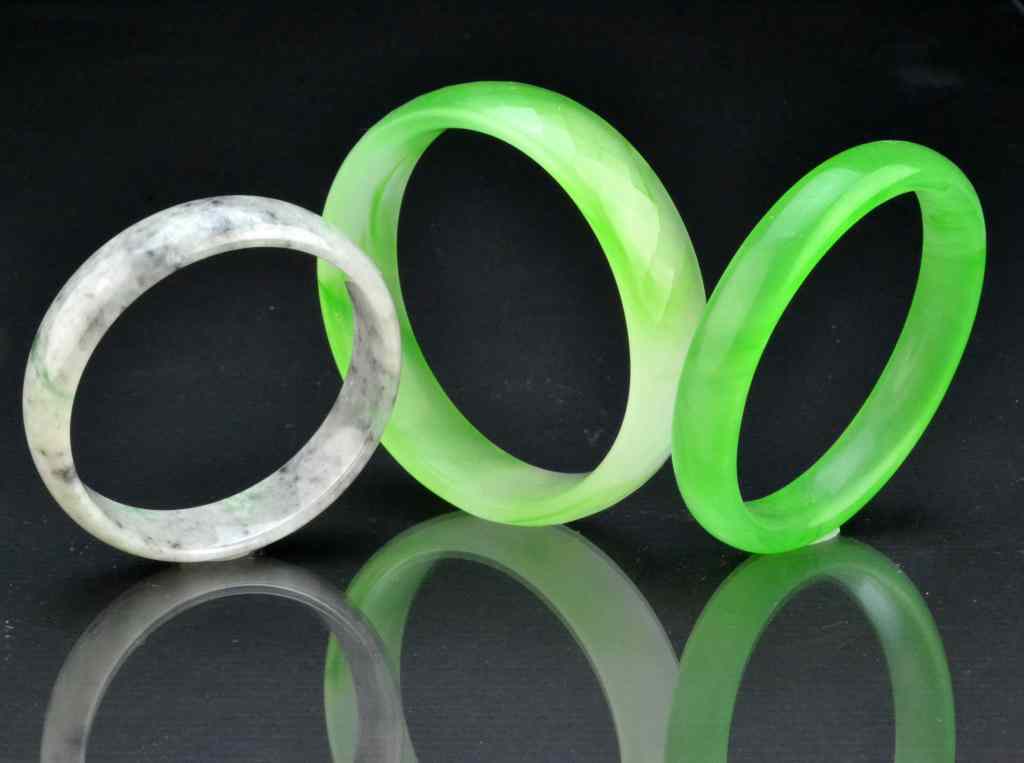 Appraisal: Chinese Carved Jade Jadeite Bangle BraceletsOne jadeite bracelets carved with