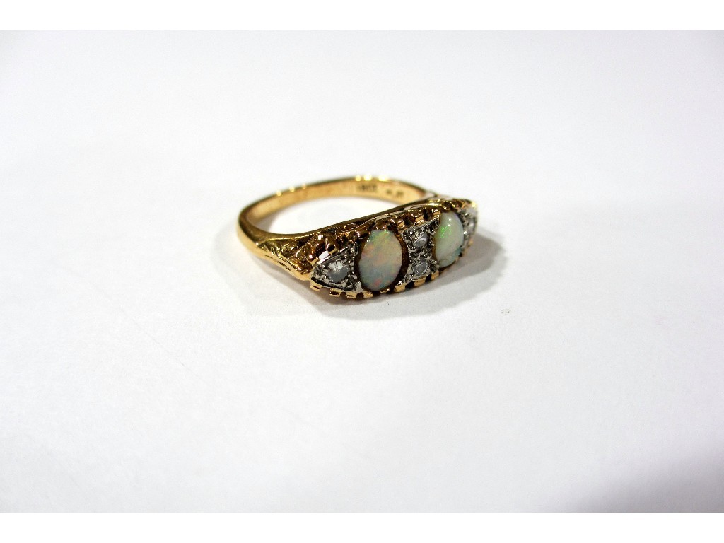 Appraisal: An opal and diamond ring with two oval opals one