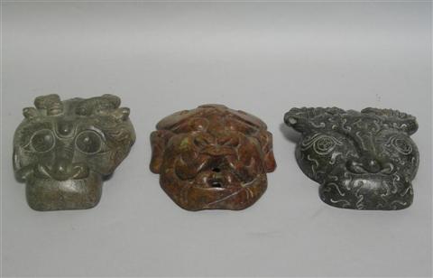 Appraisal: THREE ARCHAISTIC MASKS Of jade depicting demon an ox and