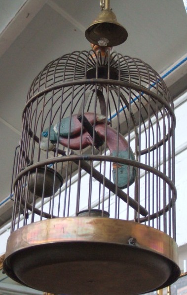 Appraisal: A gilt metal circular bird cage with turned wooden finial