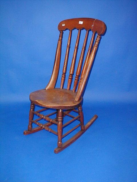 Appraisal: A Victorian spindle back rocking chair with circular saddle feet