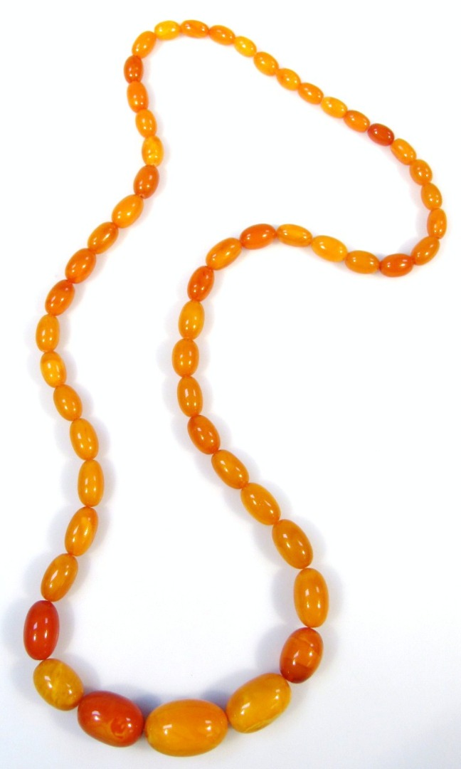 Appraisal: Various mustard coloured amber beads attached to a plain stringing