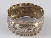 Appraisal: A silver napkin ring with scrolling and crimped sides Birmingham