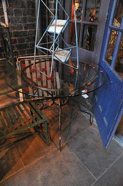 Appraisal: A CIRCULAR GLASS TOP TABLE ON WROUGHT IRON BASE