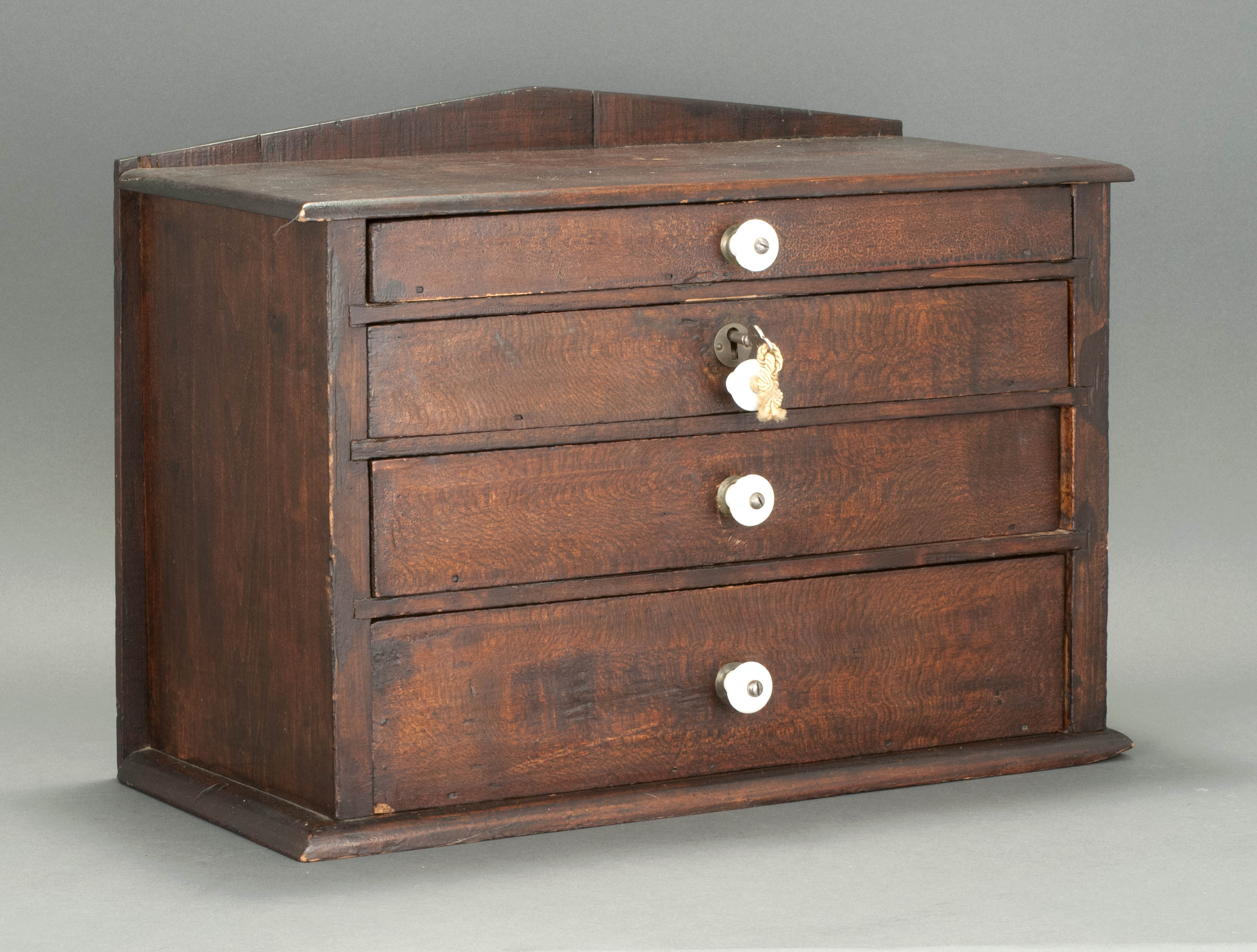 Appraisal: MINIATURE CHEST Late th CenturyIn pine with brown finish Four