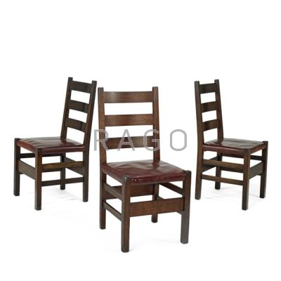 Appraisal: GUSTAV STICKLEY Three ladder-back dining chairs Oak and leather Red