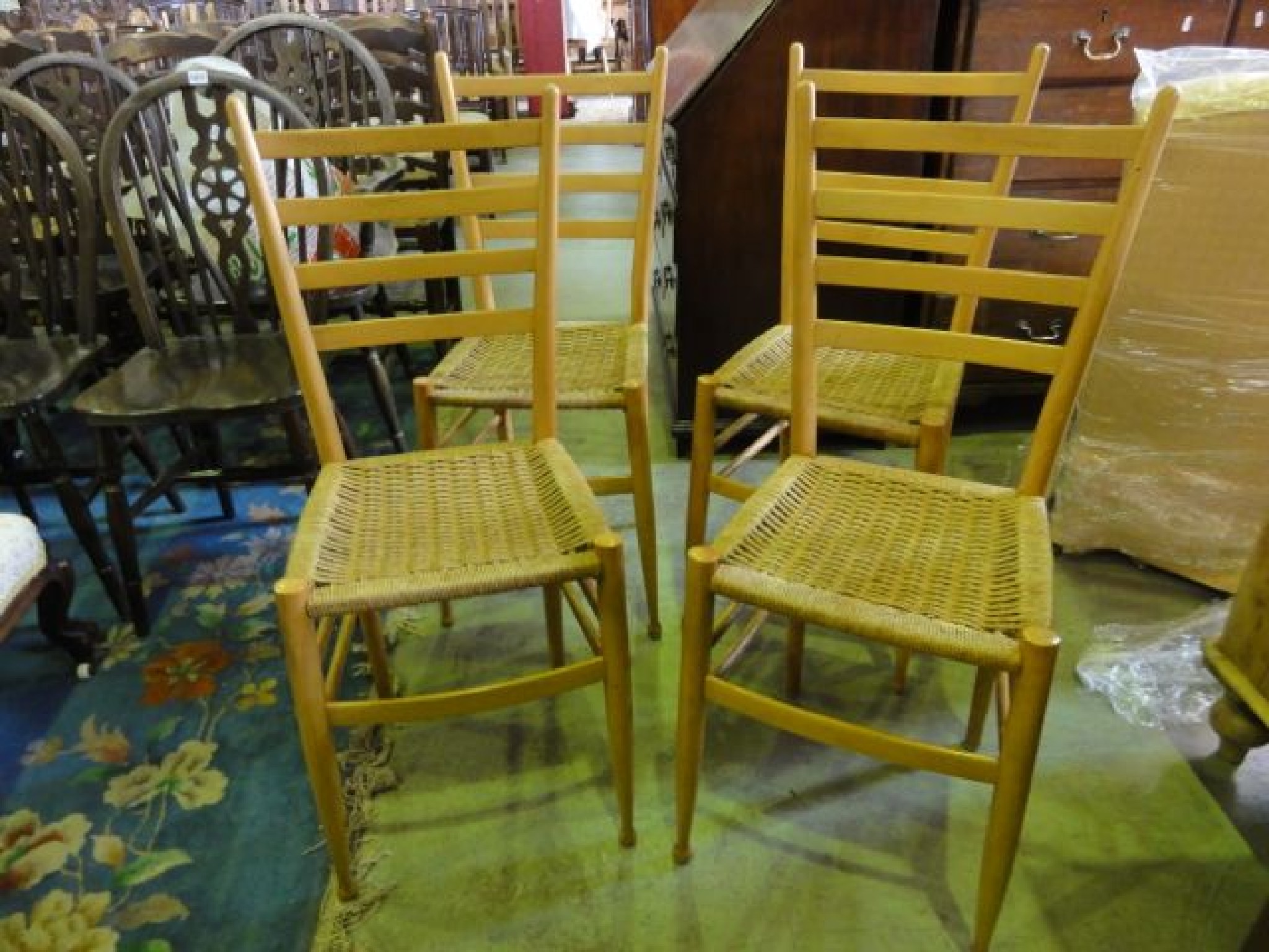 Appraisal: A set of four contemporary light beechwood framed ladder back