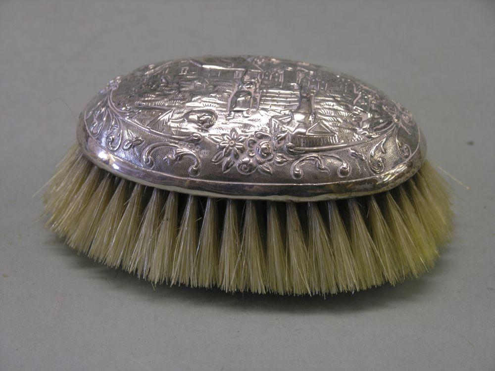 Appraisal: A continental silver clothes brush embossed with domestic scenes