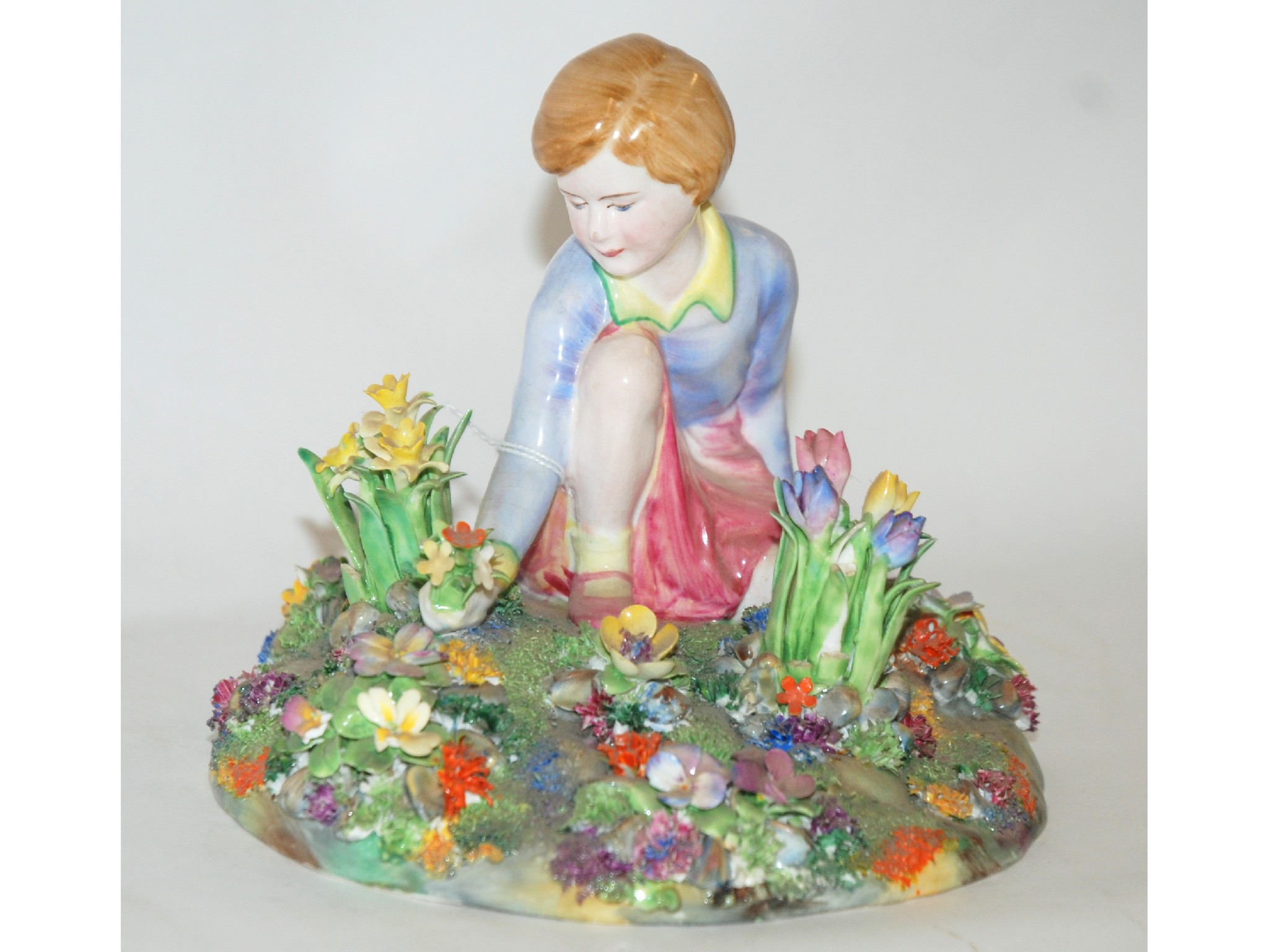 Appraisal: Crown Staffordshire model depicting a child kneeling amongst spring flowers