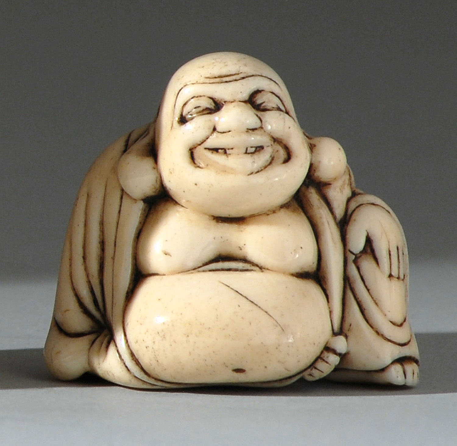 Appraisal: IVORY NETSUKE Early th CenturyDepicting a seated Hotei Signed Not