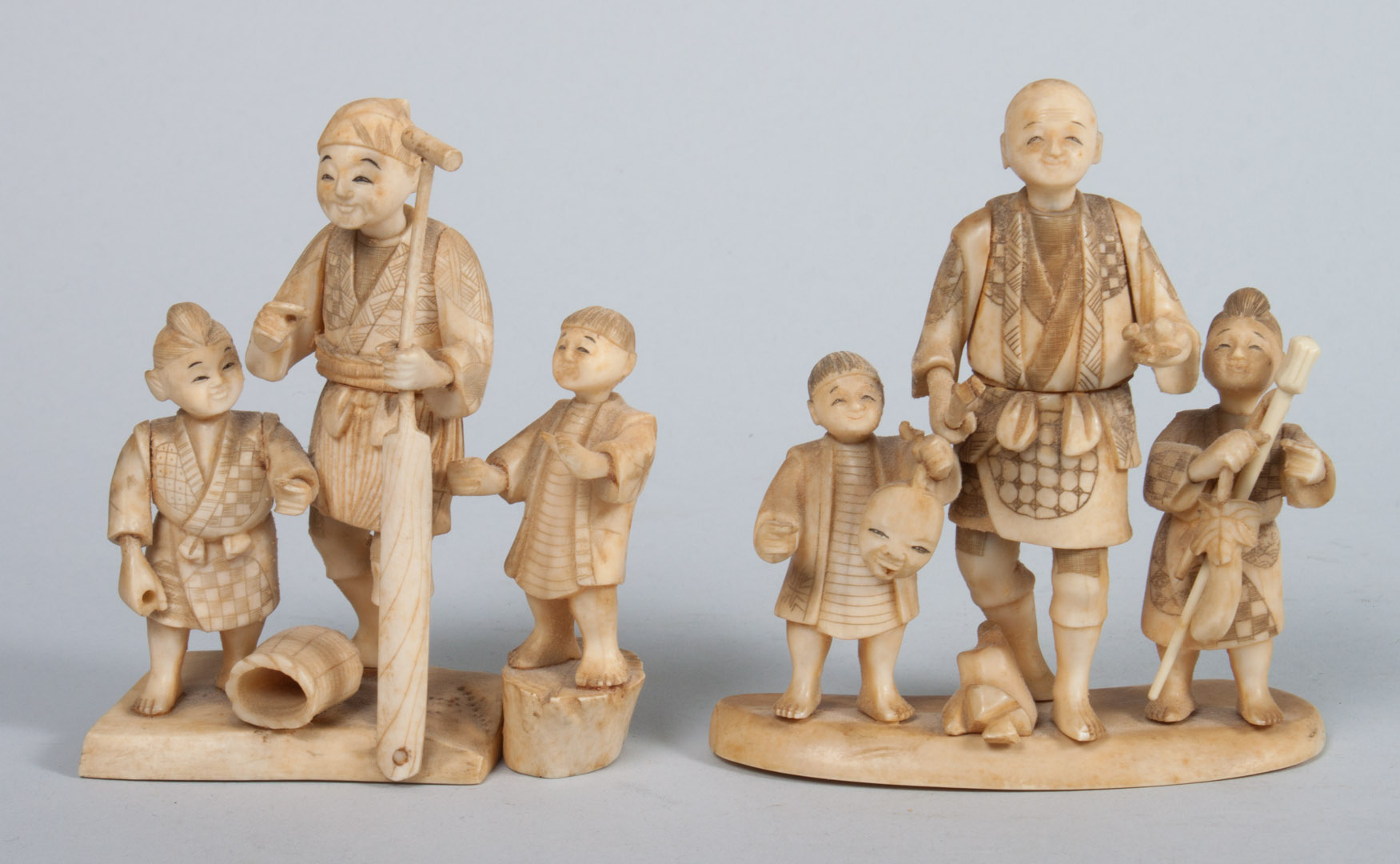 Appraisal: Two Japanese carved ivory figural groups each group consisting of