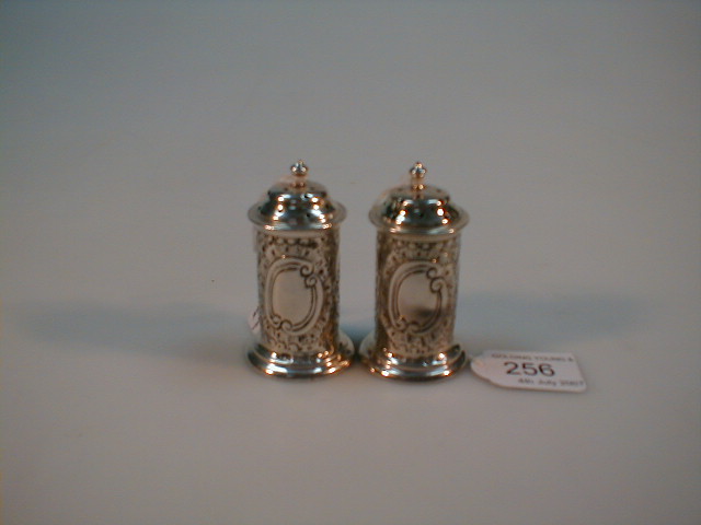 Appraisal: A pair of Victorian silver cylinder pepper pots with floral