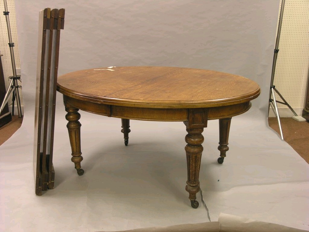 Appraisal: A Victorian oak wind-action dining table with three extra leaves