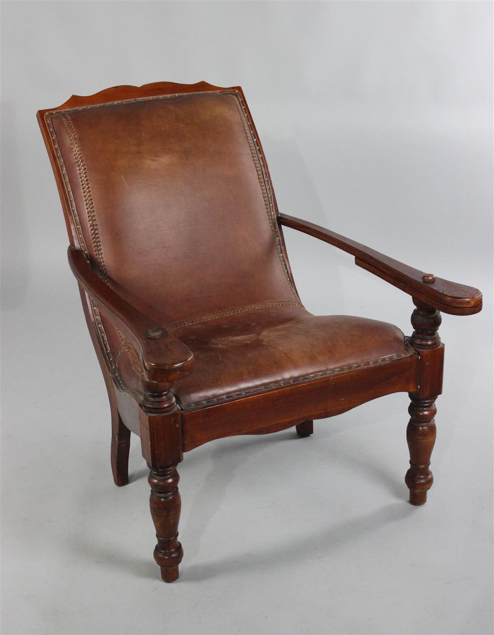 Appraisal: BRITISH COLONIAL PLANTATION CHAIR WITH LEATHER UPHOLSTERY carved crest rail