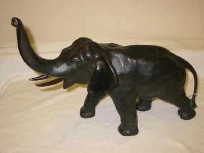 Appraisal: A BRONZE ELEPHANT modelled standing with raised trunk dark brown