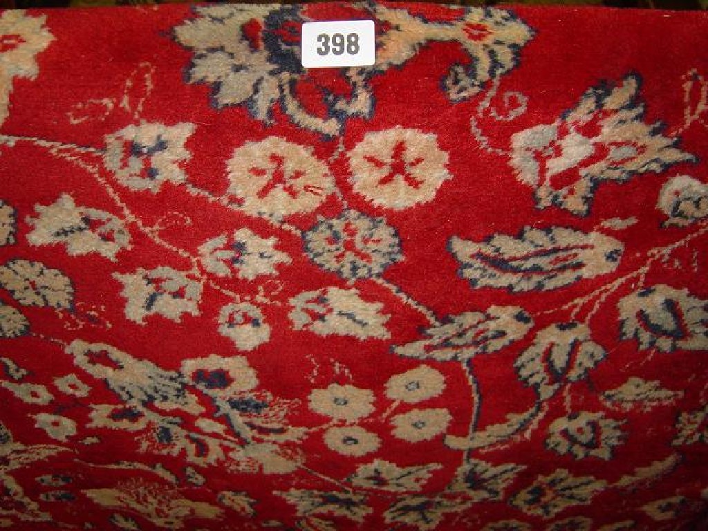 Appraisal: A red ground wool carpet with all over trailing leaf