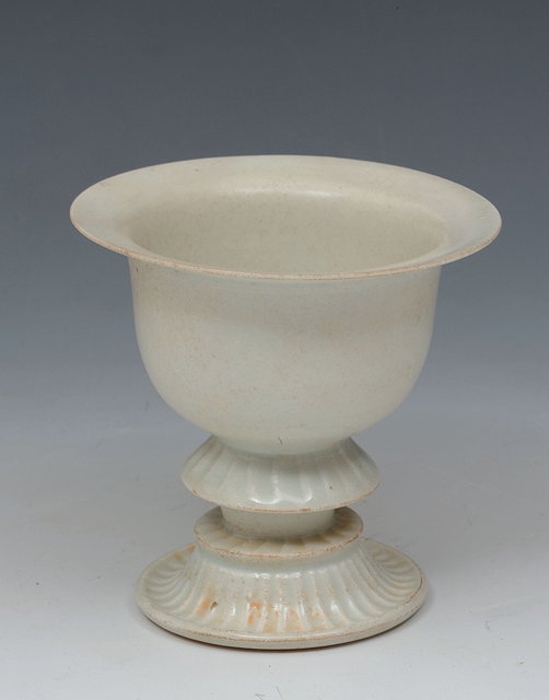 Appraisal: A CHINESE WHITE GLAZE PEDESTAL CUP with reeded upturned circular