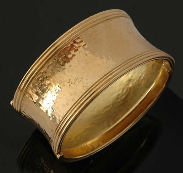 Appraisal: A wide gold bangle The concave hinged bangle with hammered