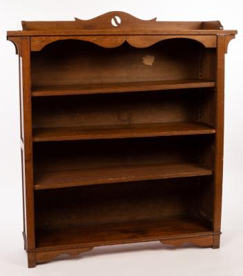 Appraisal: An Arts Crafts style oak bookcase with pierced cresting above