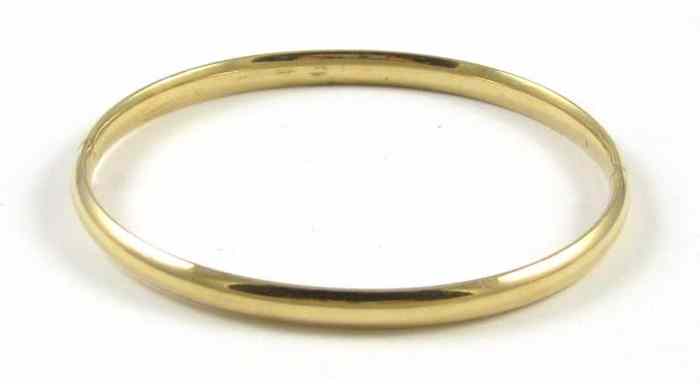 Appraisal: FOURTEEN KARAT GOLD BANGLE The oval hinged bangle weighs grams