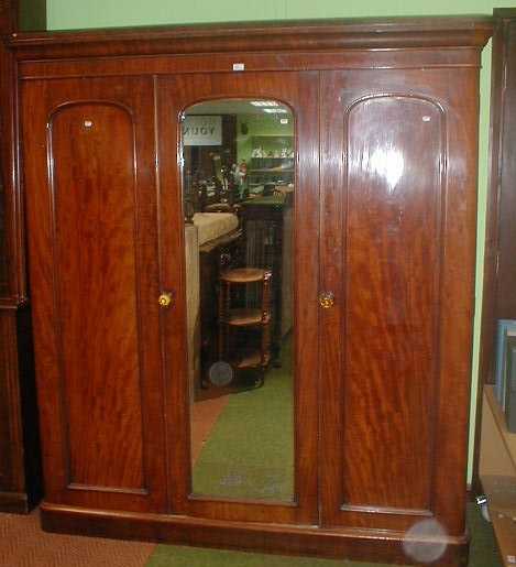 Appraisal: A Victorian mahogany triple wardrobe compactum with rounded and moulded