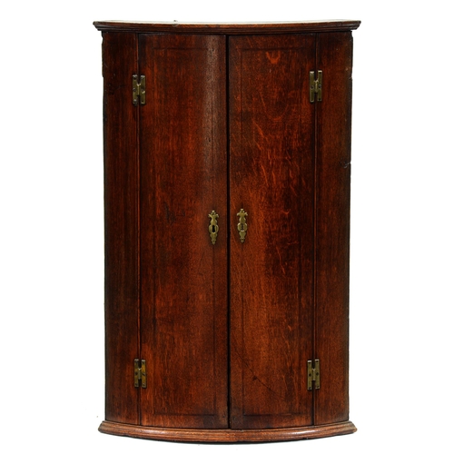 Appraisal: A George III bow fronted oak hanging corner cupboard brass