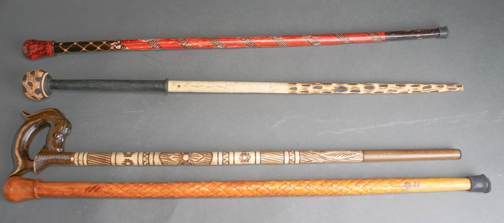 Appraisal: COLLECTION OF FOUR CARVED WOOD WALKING STICKS L OF LARGER