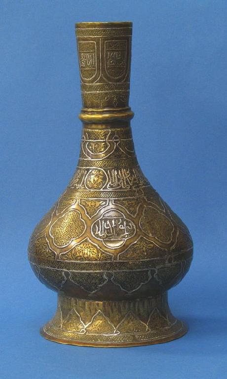 Appraisal: AN ISLAMIC BRASS BOTTLE VASE with silver inlay and chased