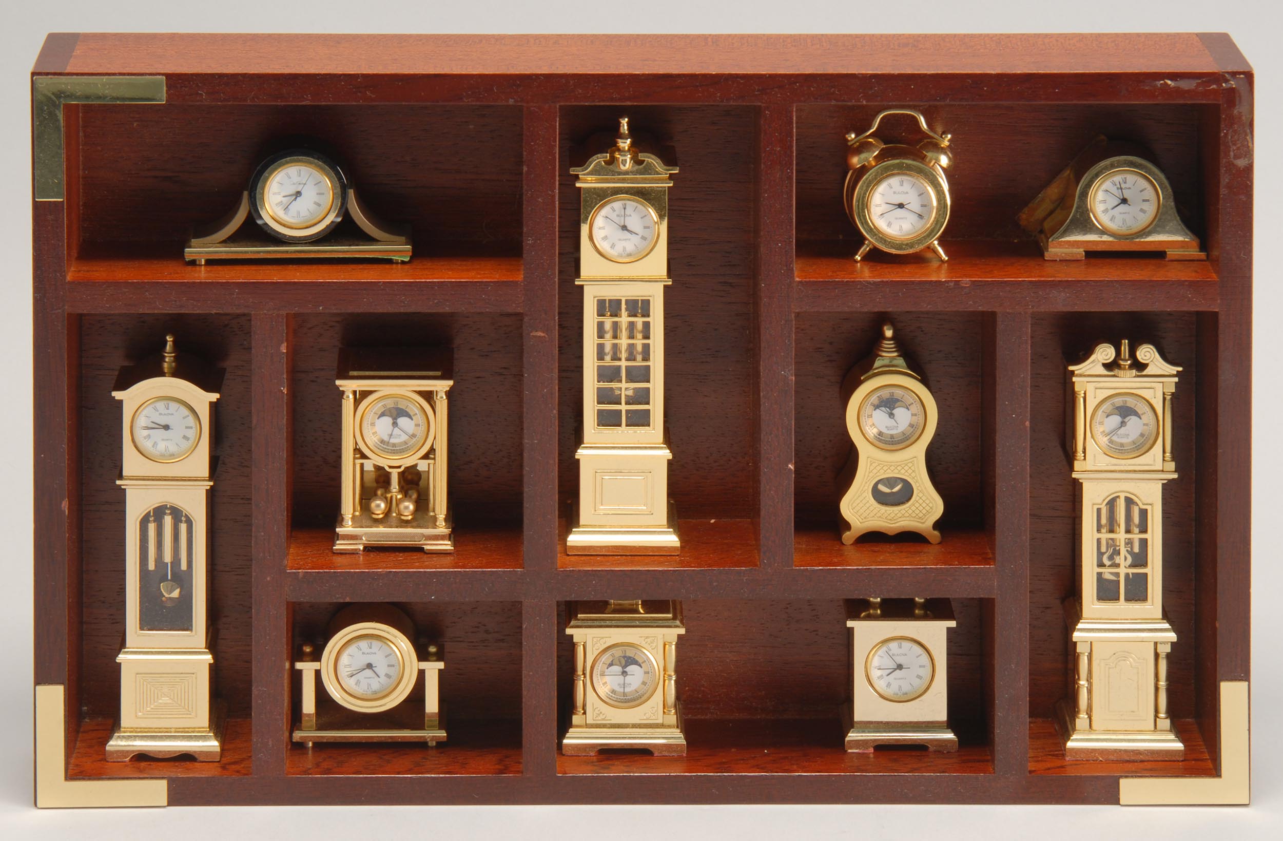 Appraisal: DESK-TOP DISPLAY CASE CONTAINING MINIATURE QUARTZ CLOCKS by Bulova Includes