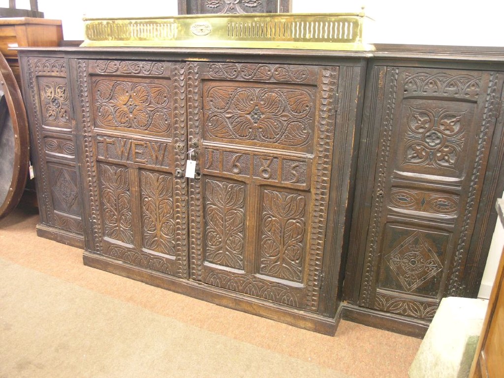 Appraisal: A dark carved oak break-fronted side cupboard made from some