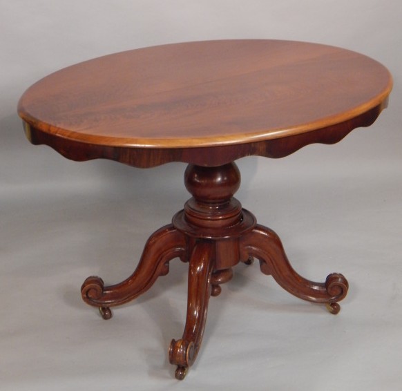 Appraisal: A Victorian walnut oval breakfast table on a turned column