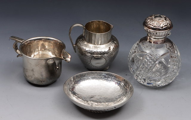 Appraisal: A SMALL SILVER BALUSTER SHAPED JUG with a planished finish