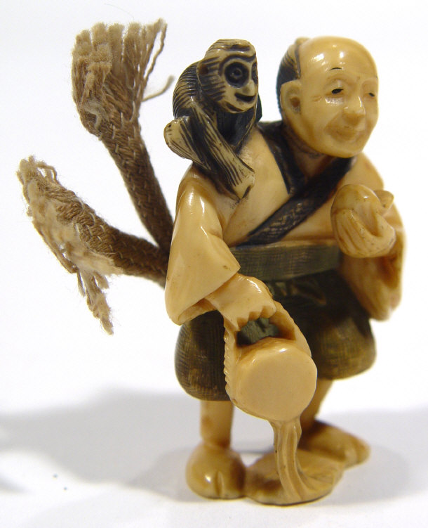 Appraisal: Oriental ivory Netsuke carved as a man with a monkey