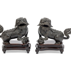 Appraisal: A Pair of Chinese Bronze Buddhistic Lions with Wood Stands