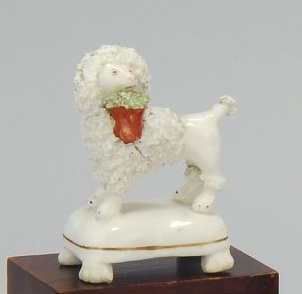 Appraisal: STAFFORDSHIRE FIGURE OF A POODLE WITH FLOWER BASKET Circa White