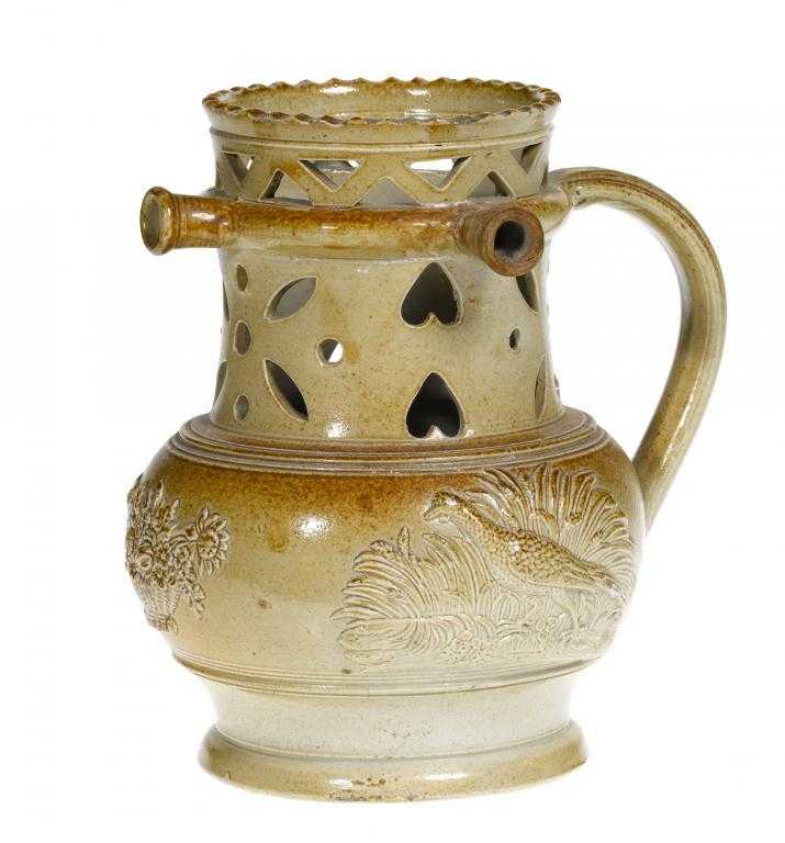 Appraisal: A DERBYSHIRE SALTGLAZED BROWN STONEWARE PUZZLE JUG with reticulated neck