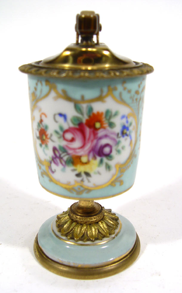 Appraisal: Brass and china table lighter hand enamelled with flowers onto