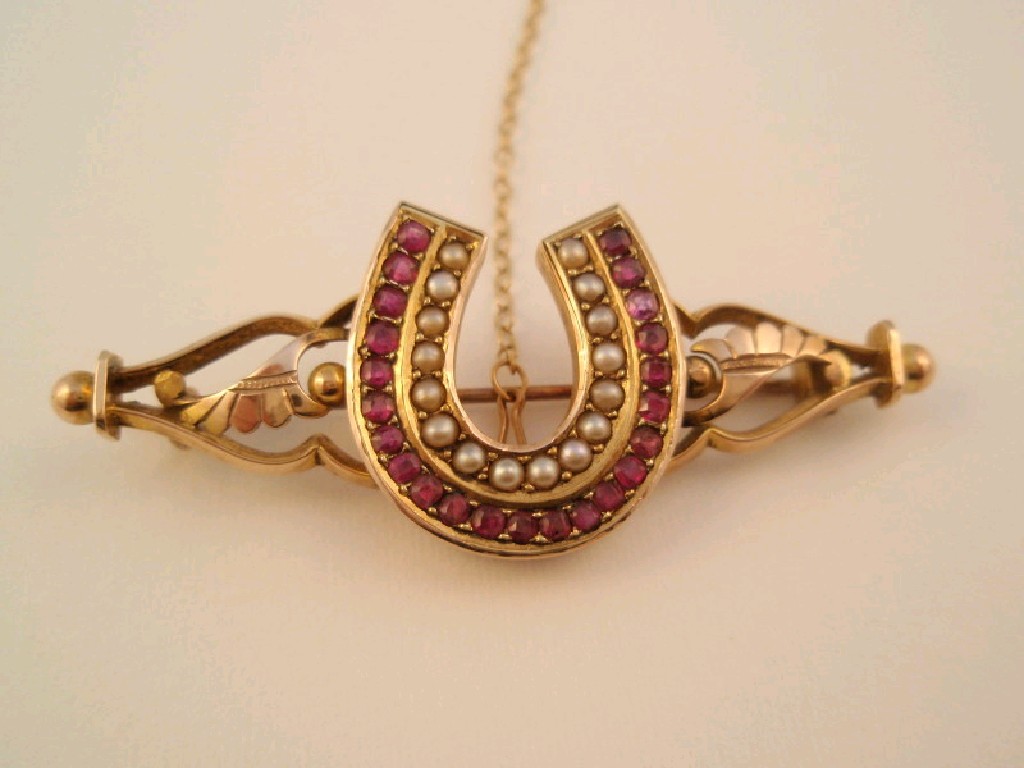 Appraisal: A Victorian horseshoe brooch set with rows of tiny rubies