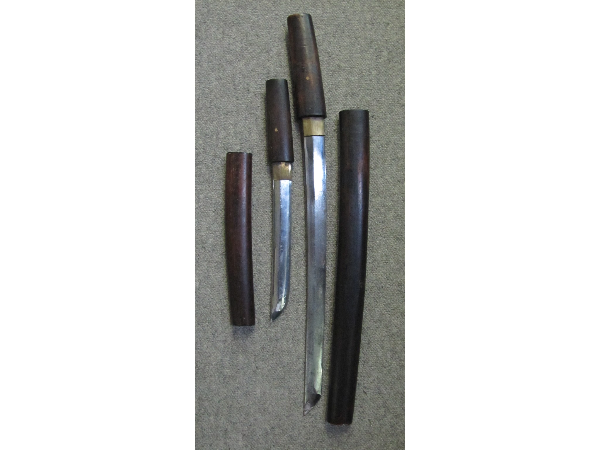 Appraisal: A lot comprising two Japanese daggers in wooden sheathes