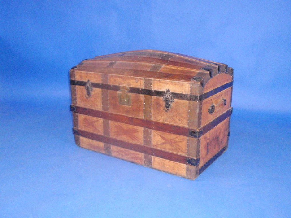 Appraisal: A tooled leather travel trunk with domed top polished elm