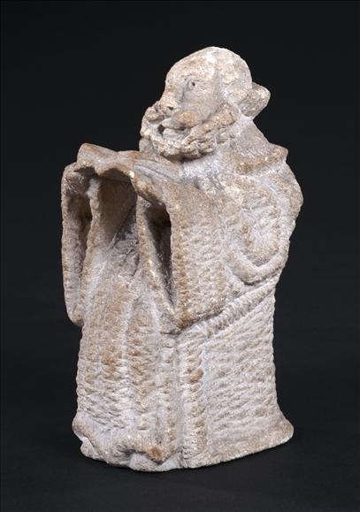 Appraisal: A carved limestone figure of a priest th century holding