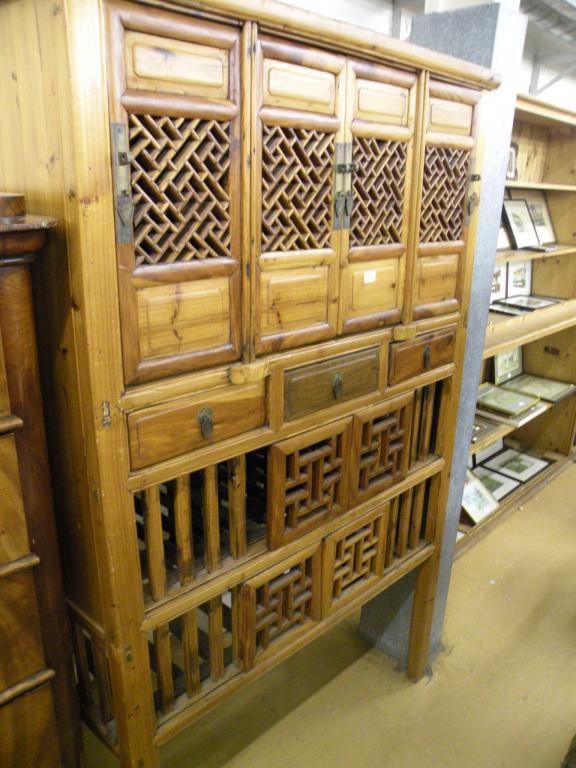 Appraisal: An oriental pine cupboard with an arrangement of four doors