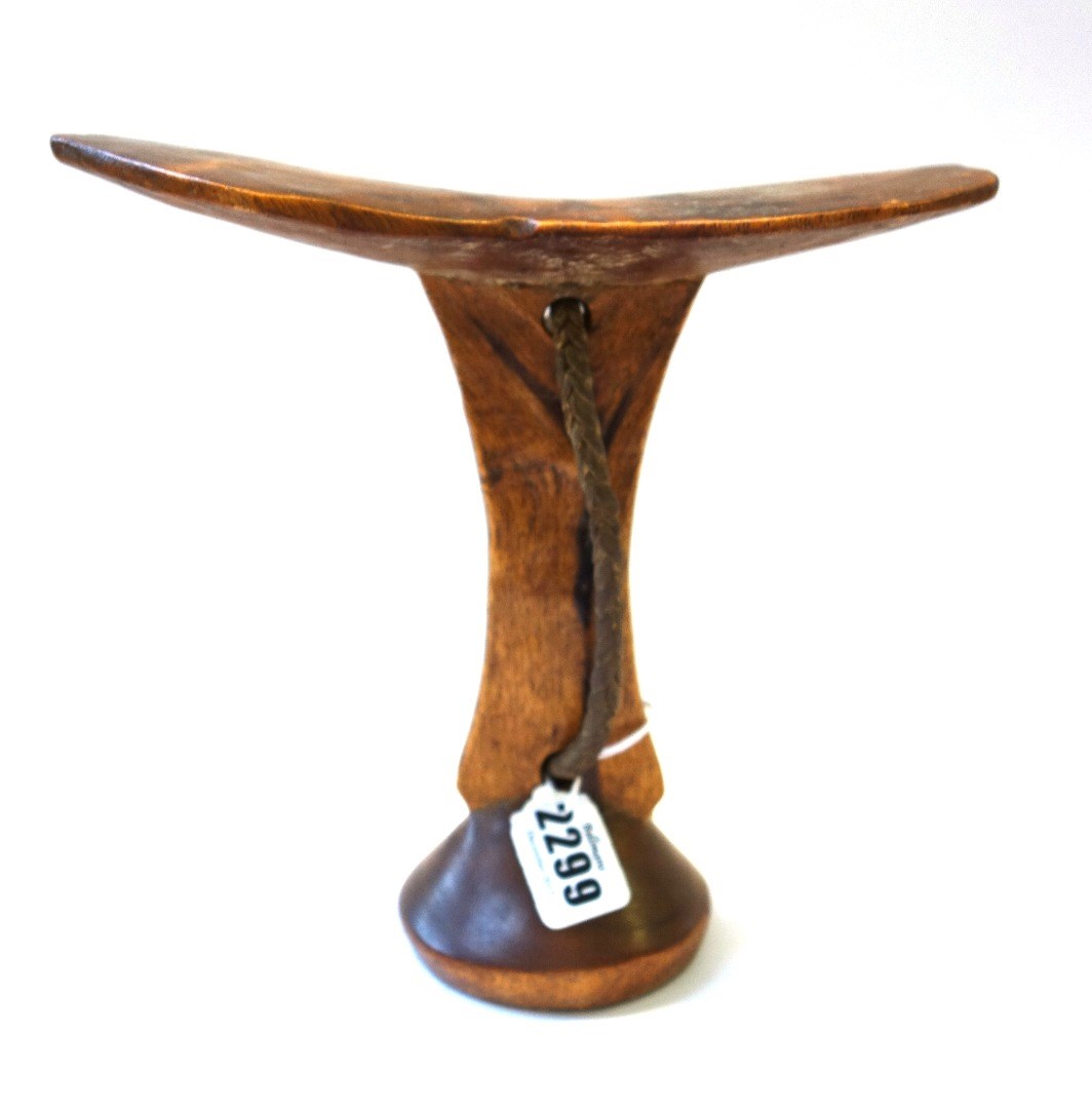 Appraisal: An African hardwood headrest early th century raised on a