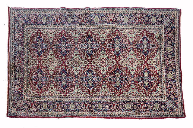 Appraisal: A PERSIAN KIRMAN RED GROUND RUG decorated with a design