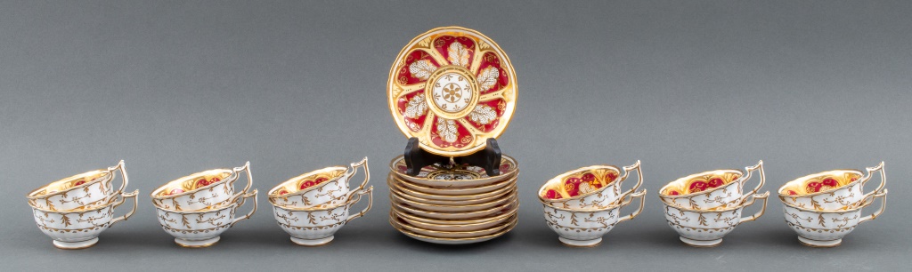 Appraisal: PARCEL-GILT RED PORCELAIN TEACUPS SAUCERS Royal Worcester style parcel gilded