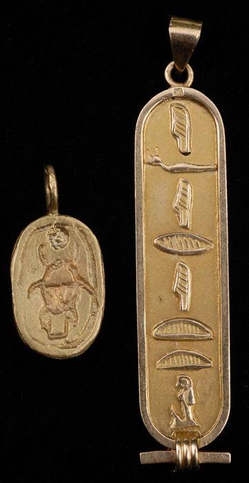 Appraisal: MODERN EGYPTIAN-STYLE CARTOUCHE PENDANT Together with another small pendant both