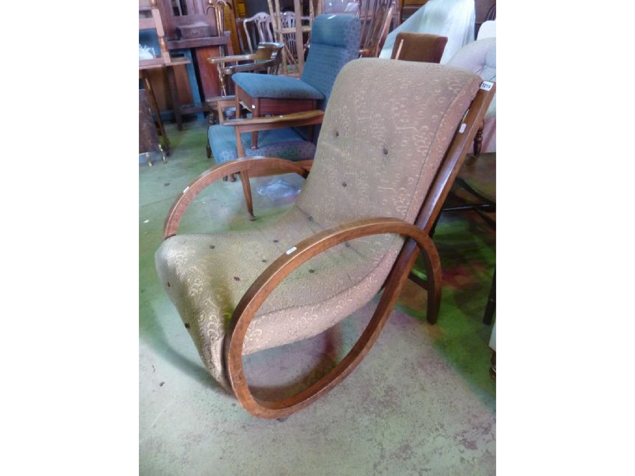 Appraisal: An Art Deco fireside chair with single piece curved framework